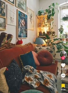 a living room filled with lots of furniture and pictures on the wall next to a window