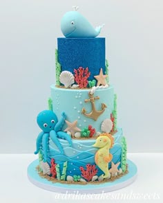 a three tiered cake decorated with an octopus and sea animals