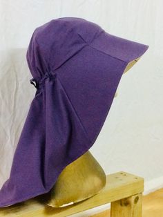 a purple hat sitting on top of a wooden bench