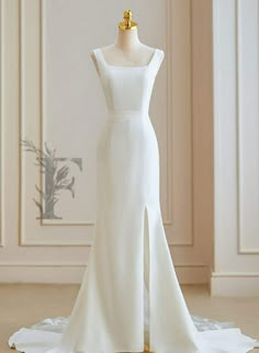 a white wedding dress on display in a room