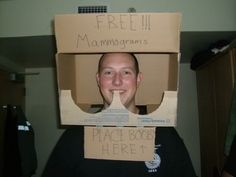 a man wearing a cardboard box on his head with the words free mammagrams written on it