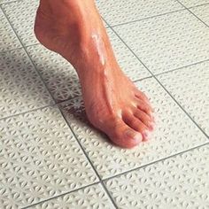 a close up of a person's bare foot on a tiled floor