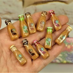 there are many miniature bottles in the palm of someone's hand