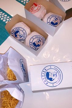 three boxes filled with food sitting on top of a white table next to each other