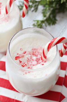 two glasses filled with milk and candy canes