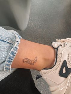 a woman's foot with a small tattoo on her left ankle and an air max running shoe