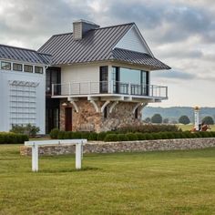 a large white house sitting on top of a lush green field