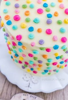 a cake with white frosting and multicolored sprinkles on it