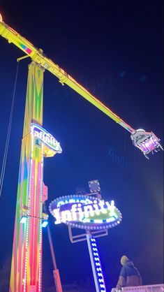 an amusement park ride at night with people on the rides and lights in the background