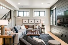 a living room with couches, tables and pictures on the wall in it's center