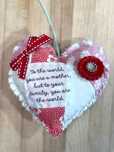 a heart shaped ornament with a quote on it