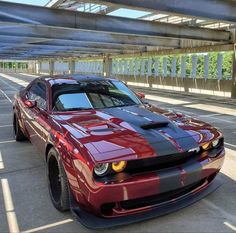 a red and black car parked under an overpass