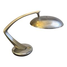 a silver desk lamp on a white background with clippings to the side and one light turned off