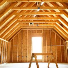 an unfinished room with wooden walls and beams