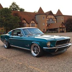 a green mustang parked in front of a large building with two story brown brick buildings