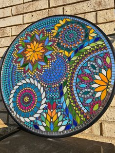 a stained glass plate sitting on top of a brick wall