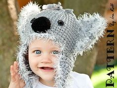 a young child wearing a knitted koala hat