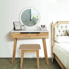 a bedroom with a bed, desk and mirror on it's side by the wall