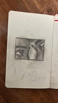 an open notebook with a drawing of a woman's face on the cover and another image of a man's eye