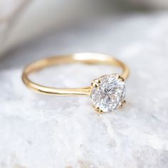 a close up view of a gold ring with a white diamond on the top and bottom