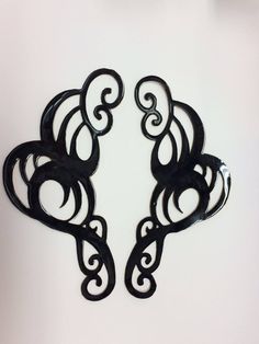 two black metal wall hangings on a white wall