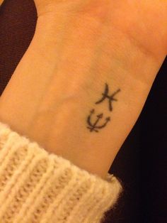 a person with a small anchor tattoo on their wrist