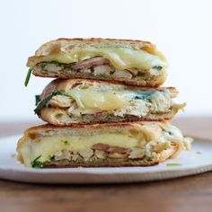 three sandwiches stacked on top of each other with cheese and meat in between the two halves