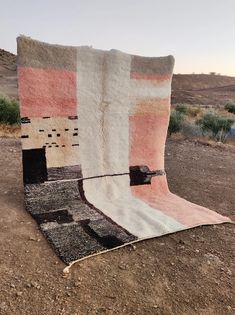 a blanket sitting on top of a dirt field