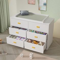 a baby crib with drawers and toys on the floor