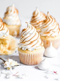 several cupcakes with white frosting and sprinkles