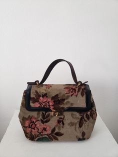 Vintage burnout velvet flora carpet bag in excellent condition.  Leather hand in great condition with aged condition.  Velvet has flattened under brass closure from years of use. Interior has zip pocket and 2 extra pockets.  Purse is clean with no stains or odors. Fabric colors a bright and vibrant. 12.5" wide 13" tall with handle up, handle drop is 4.5" 5" deep Vintage Beige Satchel, Vintage Floral Print Shoulder Bag, Vintage Beige Shoulder Bag With Handles, Vintage Beige Satchel With Top Carry Handle, Vintage Beige Satchel With Handles, Beige Vintage Bag With Top Carry Handle, Vintage Beige Tapestry Bag, Vintage Tapestry Travel Bag, Vintage Floral Print Tote Shoulder Bag