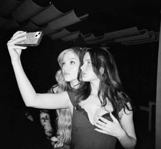 two young women taking a selfie with their cell phone in black and white photo