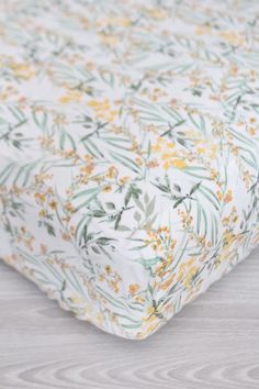 a white and yellow floral print crib sheet