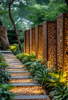 a garden path lined with plants and lights