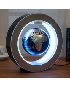 an illuminated globe sits on top of a wooden table