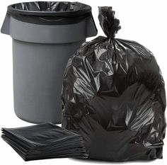 a black trash bag next to a gray trash can