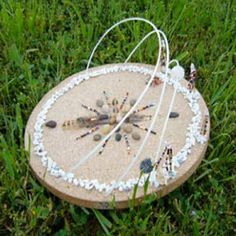 a sand clock sitting in the grass on top of it's side with beads