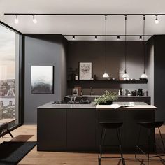 a kitchen with an island and bar stools in front of a window overlooking the city