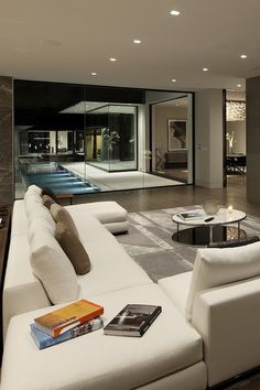 a living room filled with furniture and a large glass door leading to a swimming pool