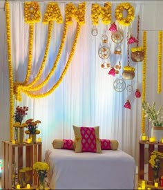 a decorated stage with yellow flowers and decorations on the wall, along with white drapes