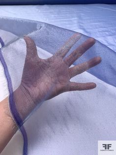 a person's hand under an umbrella covered in mosquito netting