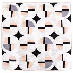 a black and white quilt hanging on a wall