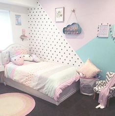 a child's bedroom with polka dot wallpaper and bedding in pastel colors