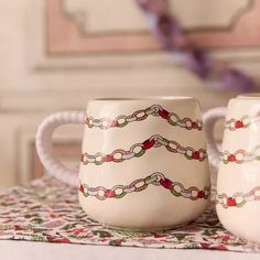 two coffee mugs sitting on top of a table