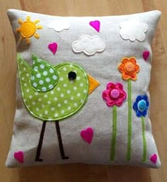 a green bird sitting on top of a pillow with flowers and clouds in the background