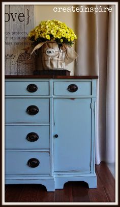 a blue dresser with yellow flowers on top