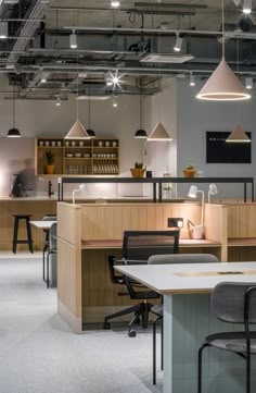 an office space with desks, chairs and lights hanging from the ceiling above them