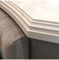 a close up view of the corner of a white marble counter top with lines on it