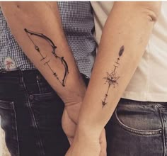 two people holding hands with tattoos on their arms and one has a star in the middle