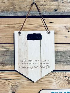 a sign hanging on the side of a wooden wall that says sometimes the smallest things take up the most room in your heart